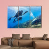 Blowfish accompanies group of tourists scuba diving at coral reef Multi panel canvas wall art