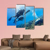 Blowfish accompanies group of tourists scuba diving at coral reef Multi panel canvas wall art