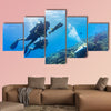 Blowfish accompanies group of tourists scuba diving at coral reef Multi panel canvas wall art