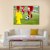 Soccer football players during the team training with ball and marker cones Multi panel canvas wall art