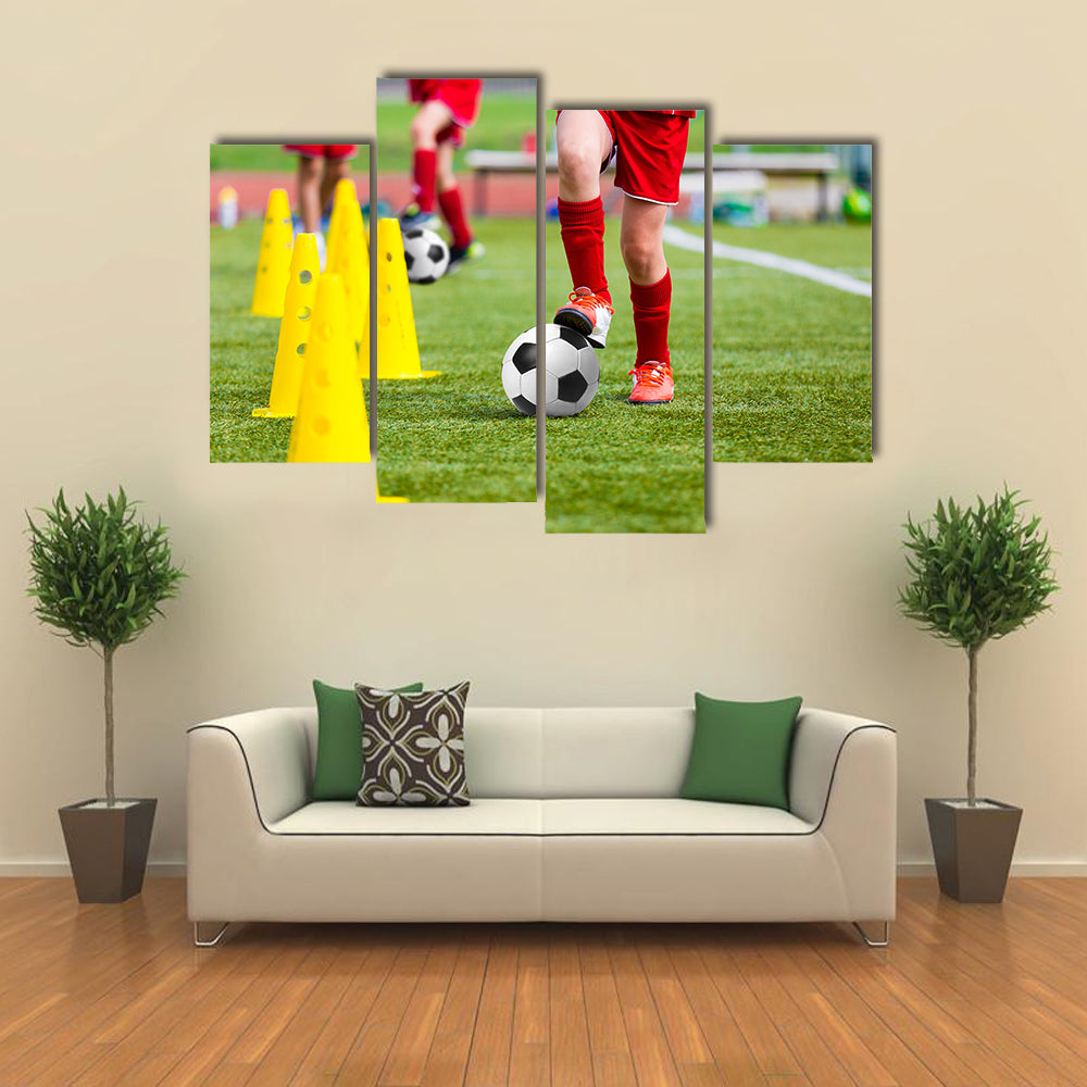 Soccer football players during the team training with ball and marker cones Multi panel canvas wall art