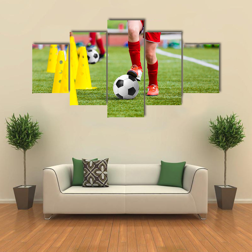 Soccer football players during the team training with ball and marker cones Multi panel canvas wall art