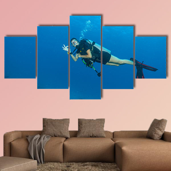 Young woman scuba diver exploring sea bottom. Showing ok sign of  wall art