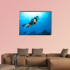 Young woman scuba diver exploring sea bottom. Underwater life with beautiful rocks and coral Multi panel canvas wall art