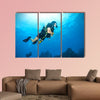 Young woman scuba diver exploring sea bottom. Underwater life with beautiful rocks and coral Multi panel canvas wall art