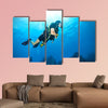 Young woman scuba diver exploring sea bottom. Underwater life with beautiful rocks and coral Multi panel canvas wall art