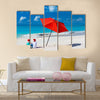 Kids in red Santa hats having fun at tropical beach during Christmas vacation Multi panel canvas wall art