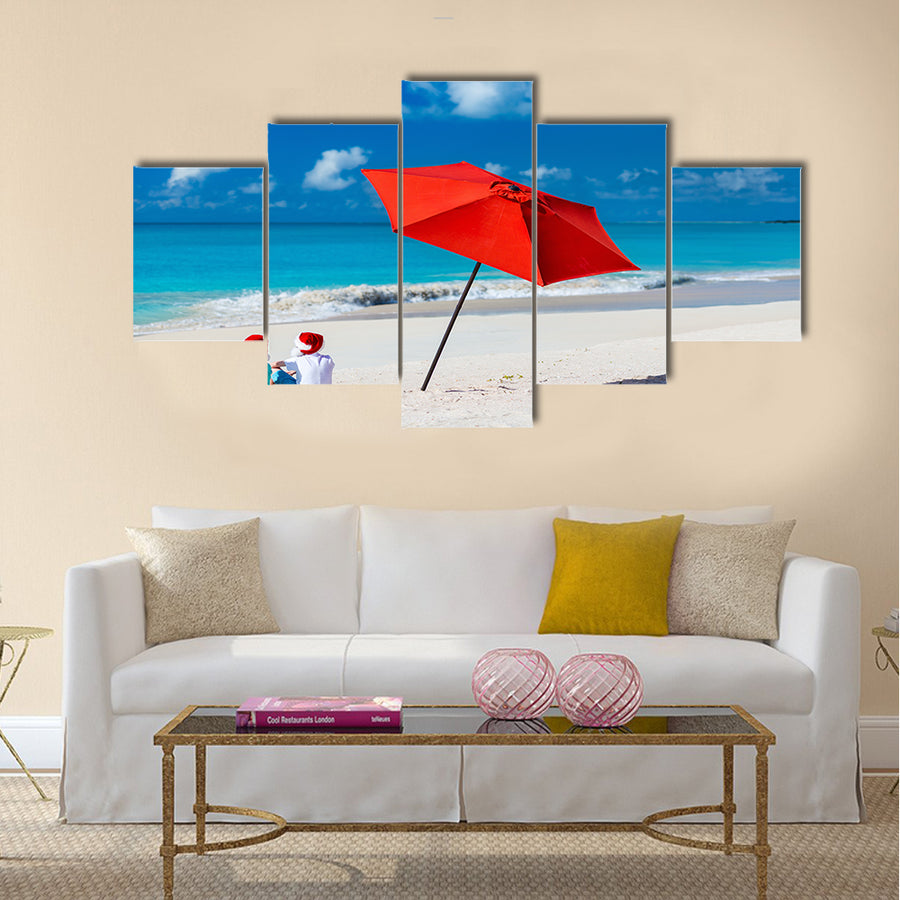 Kids in red Santa hats having fun at tropical beach during Christmas vacation Multi panel canvas wall art