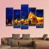 Snowy winter scene of a cabin in distance at night multi panel canvas wall art