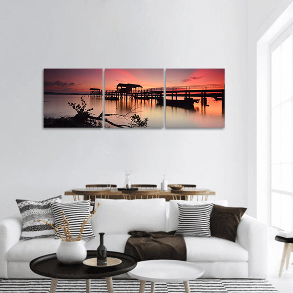 Sunset over wooden jetty with silhoutte of man fishing Panoramic canvas Wall Art