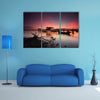 Beautiful sunset over wooden jetty with silhouette of man fishing, multi panel canvas wall art