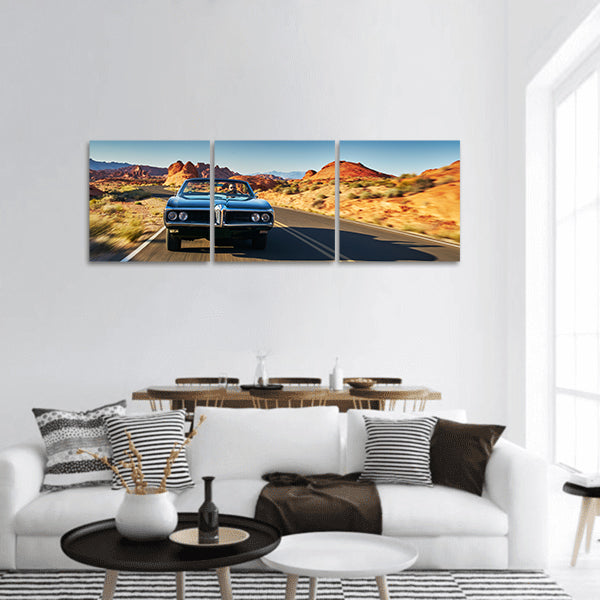 Man driving vintage car through desert Panoramic canvas Wall Art