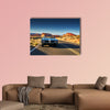 Man driving vintage car through desert multi panel canvas wall art