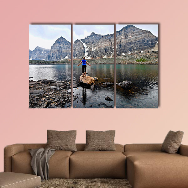 Blond woman by alpine lake enjoying the mountain view wall art