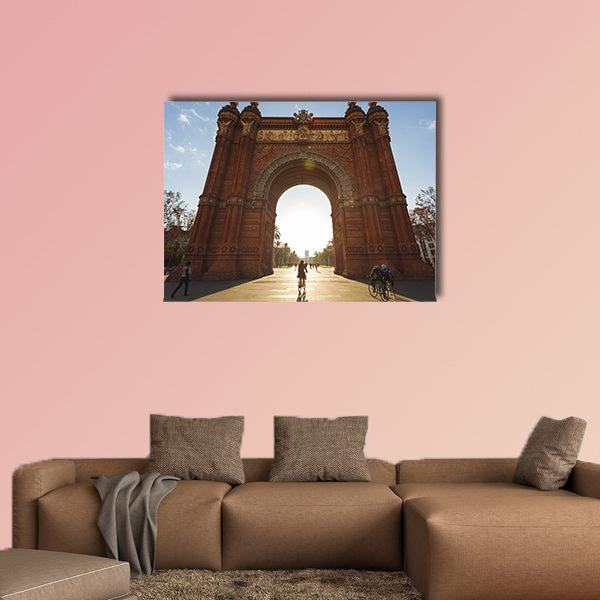 Cyclist rides into the Arc de Triomph sunny morning Barcelona, Spain canvas wall art
