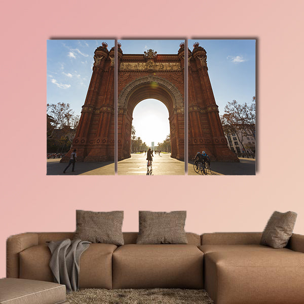 Cyclist rides into the Arc de Triomph sunny morning Barcelona, Spain canvas wall art