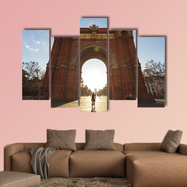 Cyclist rides into the Arc de Triomph sunny morning Barcelona, Spain canvas wall art