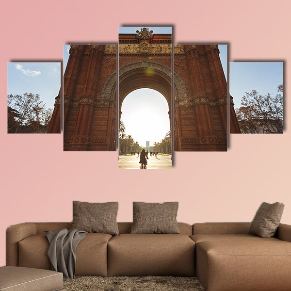 Cyclist rides into the Arc de Triomph sunny morning Barcelona, Spain canvas wall art