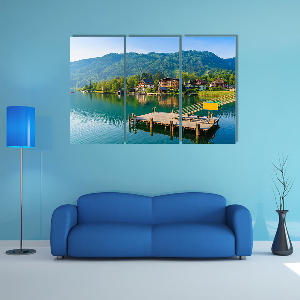 Wooden pier for boats on shore of Weissensee alpine lake in summer landscape, Austria multi panel canvas wall art