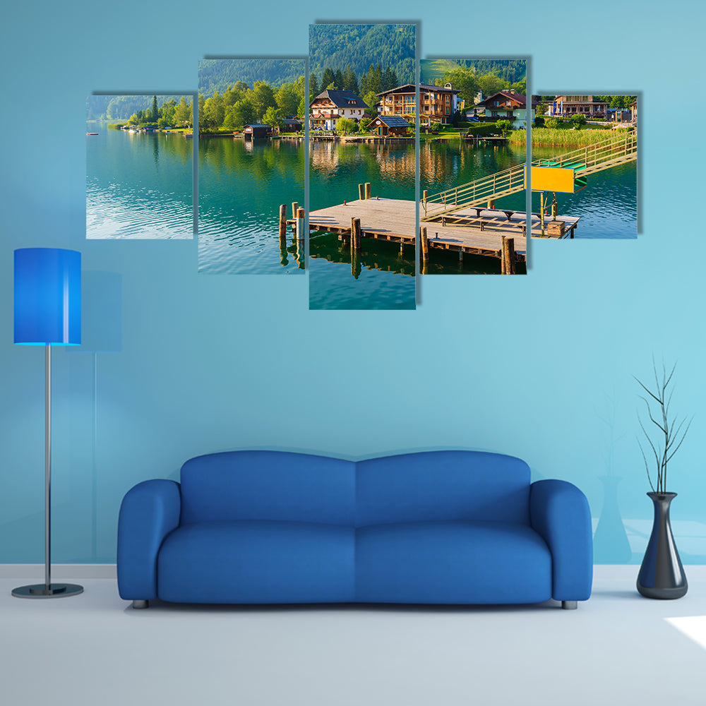 Wooden pier for boats on shore of Weissensee alpine lake in summer landscape, Austria multi panel canvas wall art