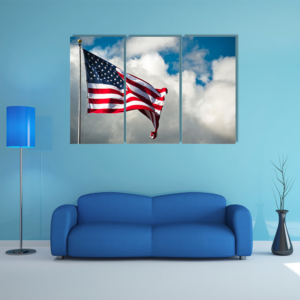 American flag against a cloudy sky on a windy day Multi panel canvas wall art
