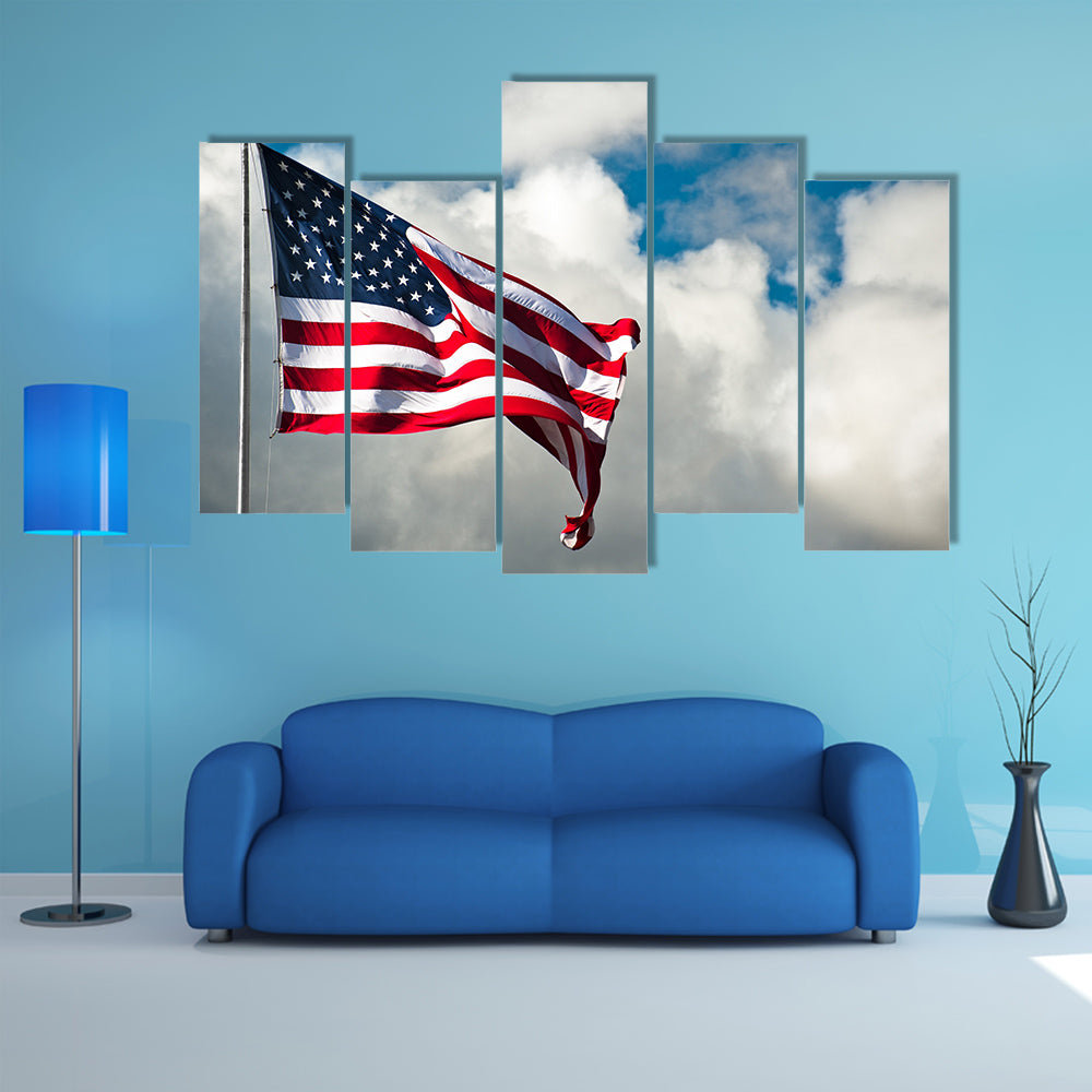 American flag against a cloudy sky on a windy day Multi panel canvas wall art