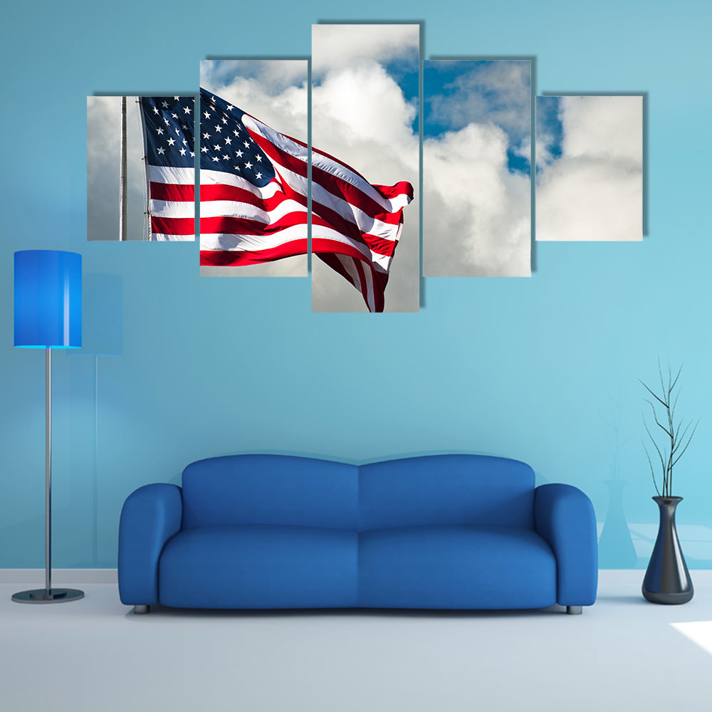 American flag against a cloudy sky on a windy day Multi panel canvas wall art