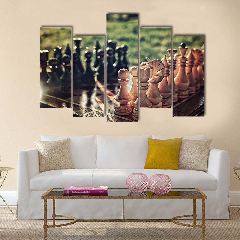 chess pieces arranged on the board mid-game in the fresh air multi panel canvas wall art