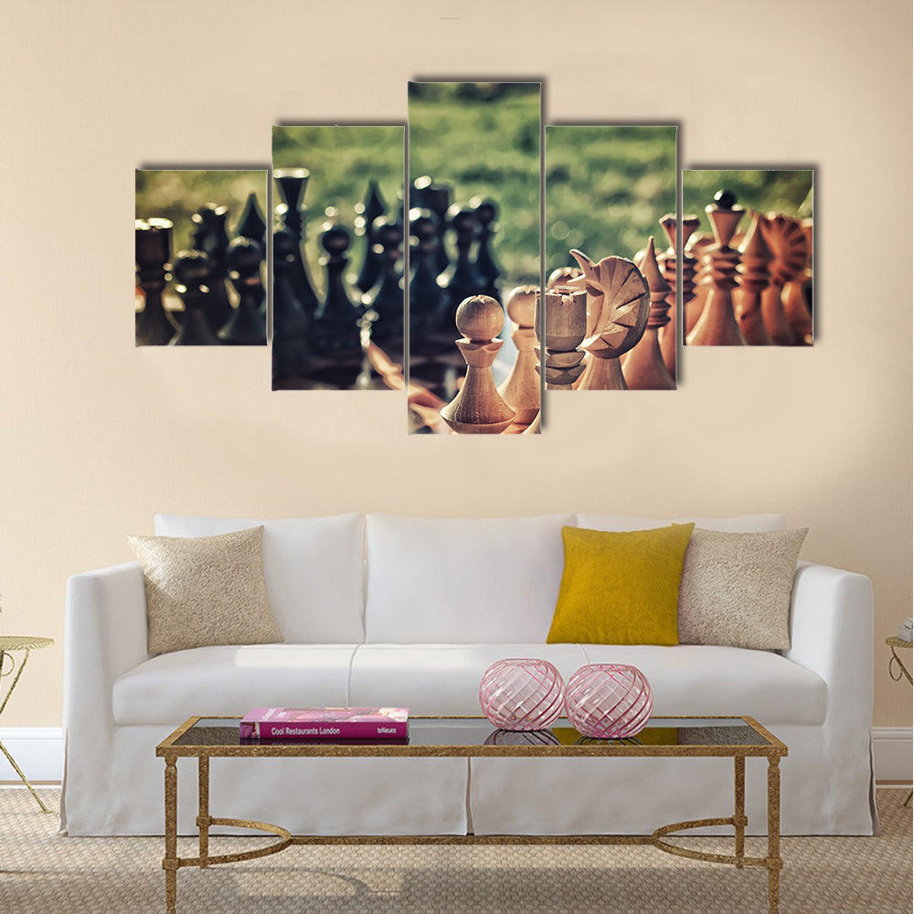 chess pieces arranged on the board mid-game in the fresh air multi panel canvas wall art
