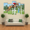 The rider on the red show jumper horse overcome high obstacles multi panel canvas wall art