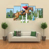 The rider on the red show jumper horse overcome high obstacles multi panel canvas wall art