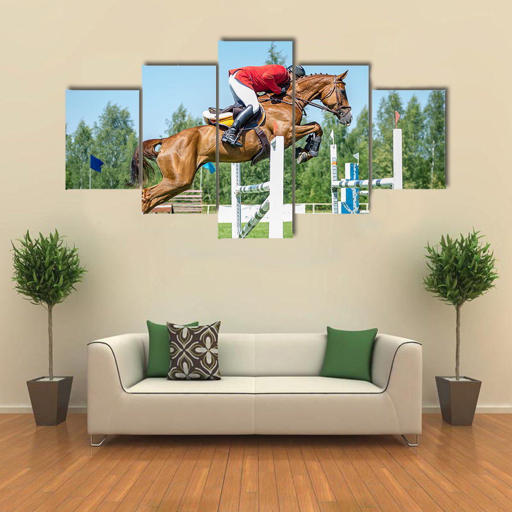 The rider on the red show jumper horse overcome high obstacles multi panel canvas wall art