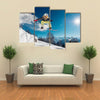 Girl is jumping with snowboard from the hill Multi panel canvas wall art