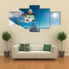 Girl is jumping with snowboard from the hill Multi panel canvas wall art