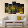 Multicolored dancing water jet fountain in the dark. multi panel canvas wall art