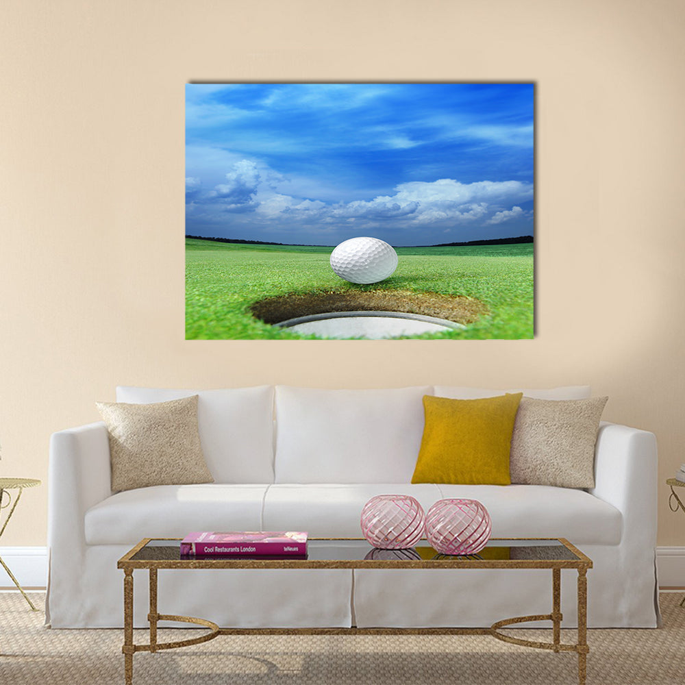Golf ball on lip of cup of lovely beautiful golf course Multi panel canvas wall art