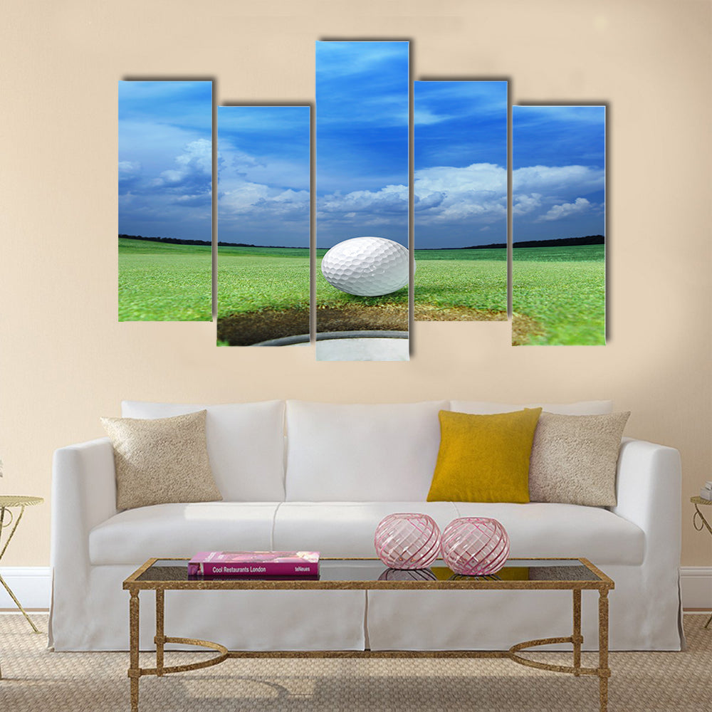 Golf ball on lip of cup of lovely beautiful golf course Multi panel canvas wall art