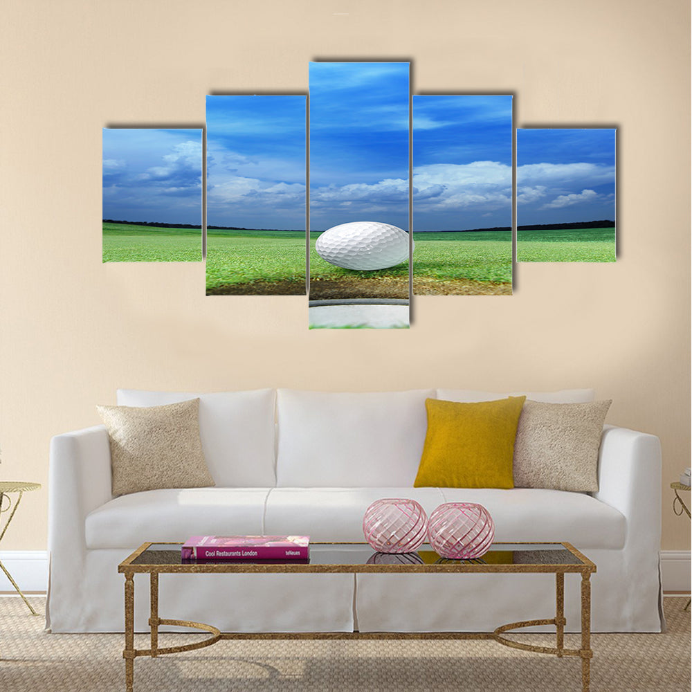 Golf ball on lip of cup of lovely beautiful golf course Multi panel canvas wall art