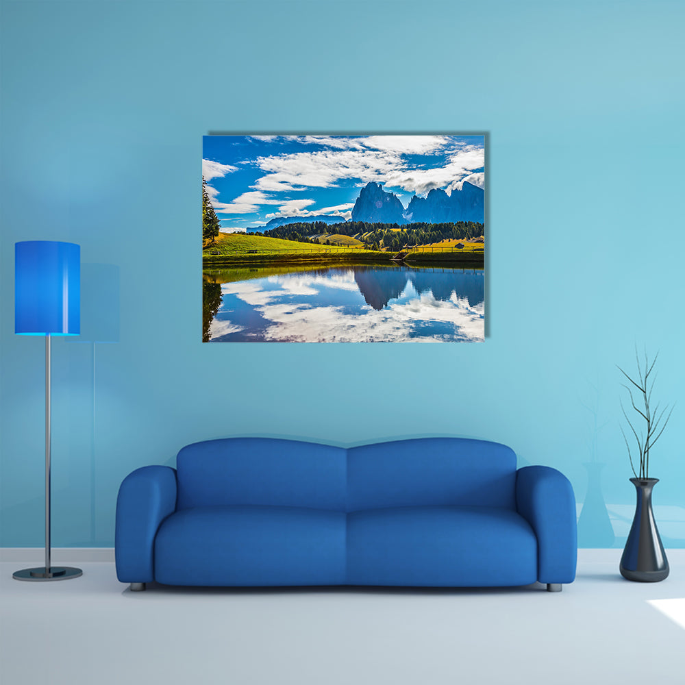 A small lake reflects the jagged rocks of the Dolomites multi panel canvas wall art