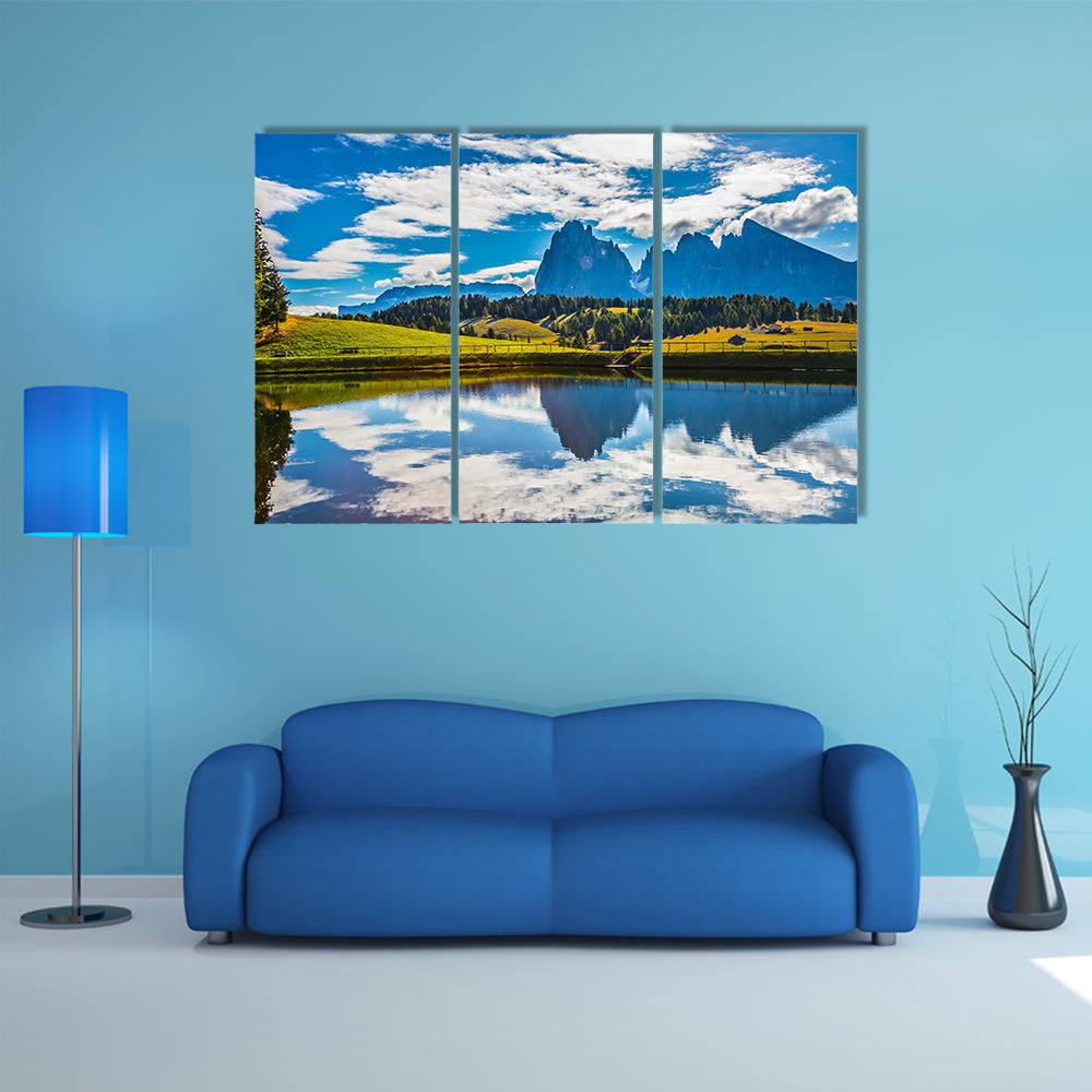 A small lake reflects the jagged rocks of the Dolomites multi panel canvas wall art