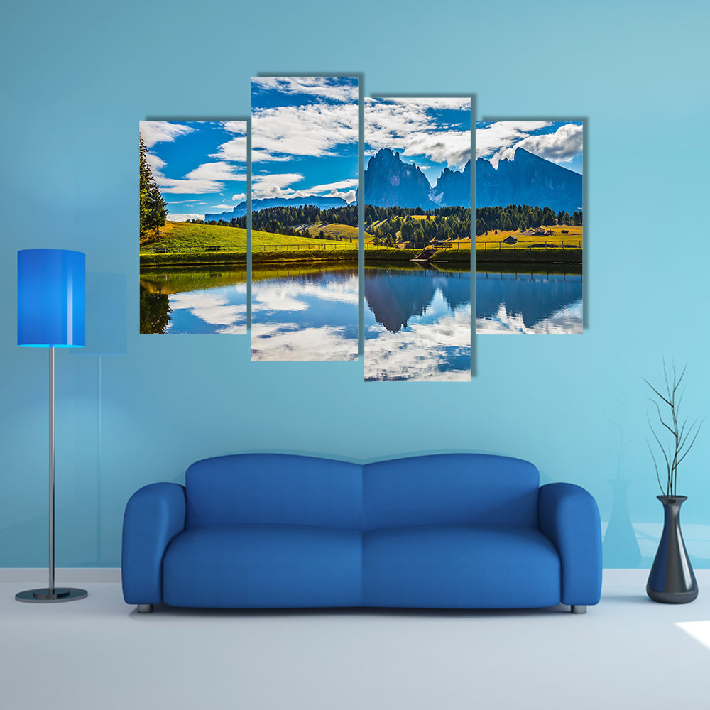 A small lake reflects the jagged rocks of the Dolomites multi panel canvas wall art