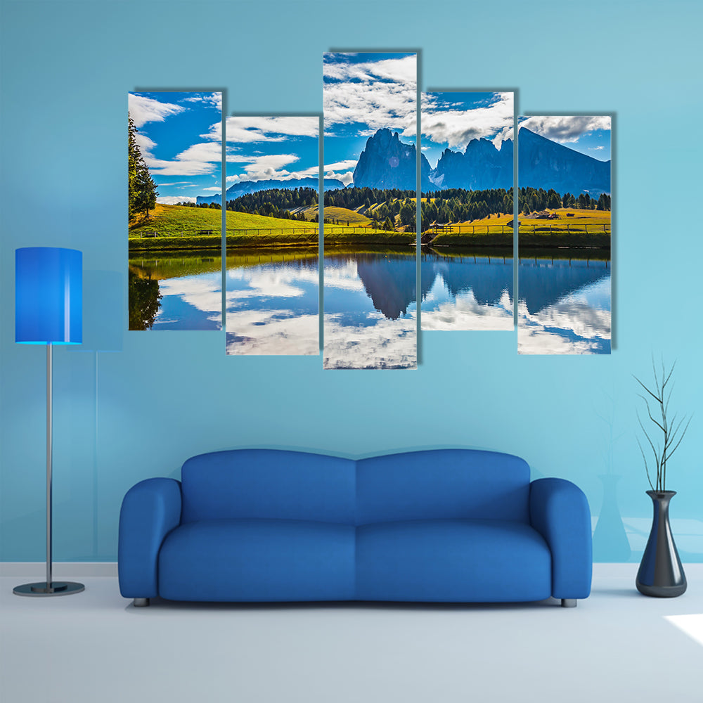 A small lake reflects the jagged rocks of the Dolomites multi panel canvas wall art