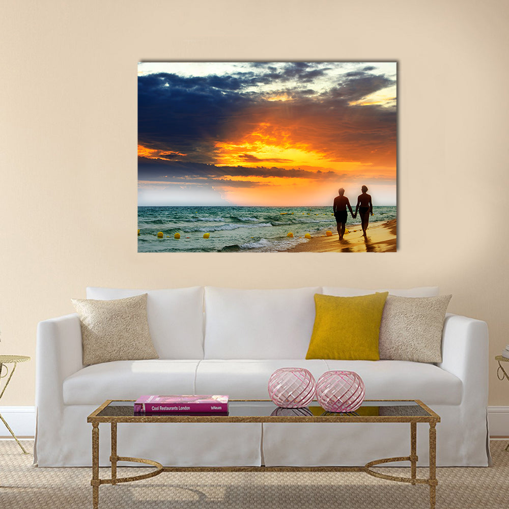 Lovers walk along the beach at sunset multi panel canvas wall art