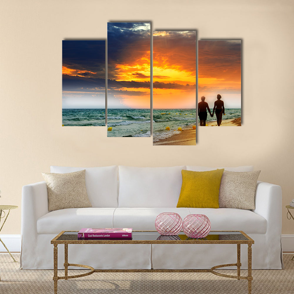 Lovers walk along the beach at sunset multi panel canvas wall art