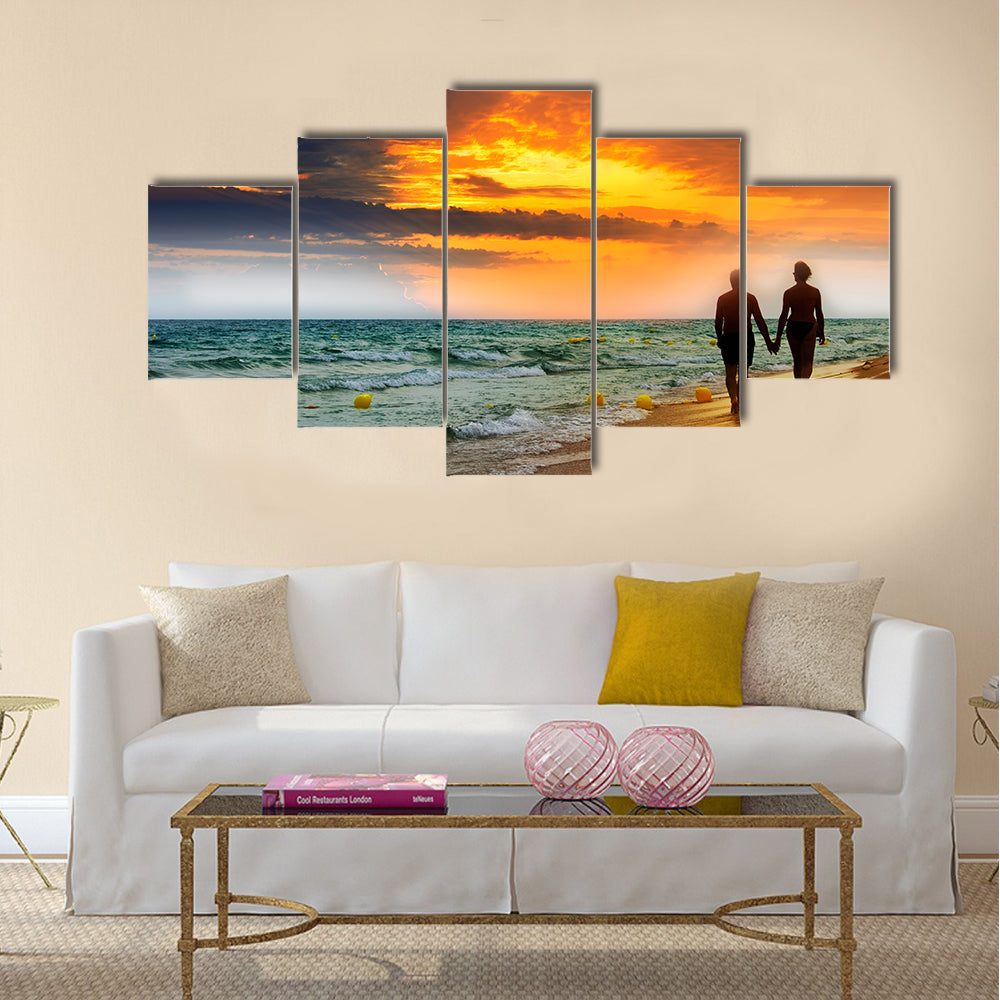 Lovers walk along the beach at sunset multi panel canvas wall art