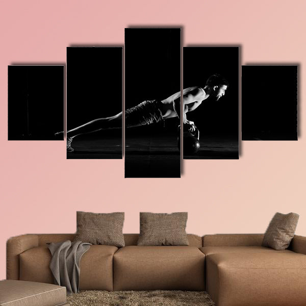 Fitness training. Man doing pushups exercise using dumbbells or weights wall art