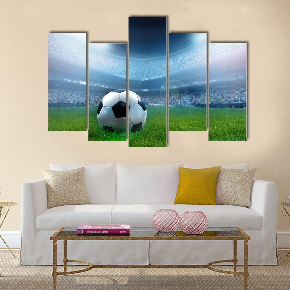 close up of a football ball on a full stadium Multi panel canvas wall art
