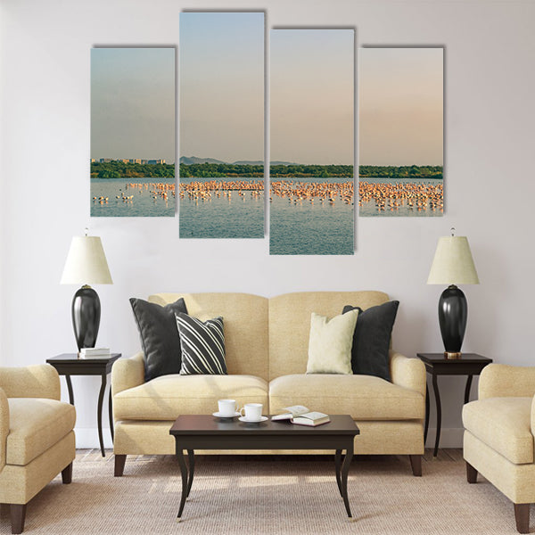 A Bunch of Flamingos Flying and Resting on a Lake Multi Panel Canvas Wall Art