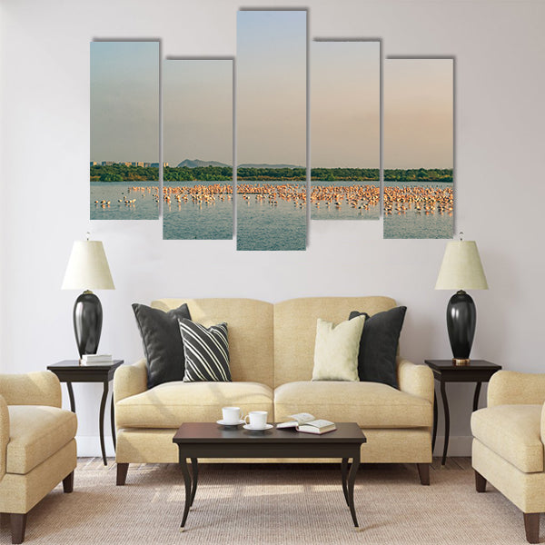 A Bunch of Flamingos Flying and Resting on a Lake Multi Panel Canvas Wall Art