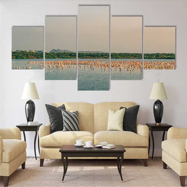 A Bunch of Flamingos Flying and Resting on a Lake Multi Panel Canvas Wall Art